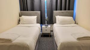 duas camas sentadas uma ao lado da outra num quarto em Garland Modern Spacious Flat, London em Londres