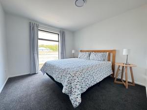 a white bedroom with a bed and a window at 10 William Jones Place in Hanmer Springs