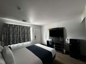 een hotelkamer met een bed en een flatscreen-tv bij Motel 6-Twin Falls, ID in Twin Falls