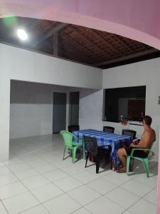 a man sitting at a table in a room at Café e Cama hospedagem in Barreirinhas