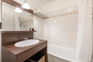 a bathroom with a sink and a bath tub at NeuvaRoom in Montévrain +12 photos