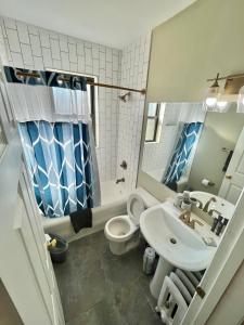 een badkamer met een wastafel, een toilet en een spiegel bij Cozy Studio in CWE near BJH in Tower Grove