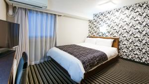 Habitación de hotel con cama y TV de pantalla plana. en APA Hotel Osaka-Tanimachi, en Osaka