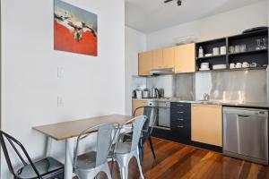 a kitchen with a table and chairs in a room at Inner-City Brisbane 1-Bed with Pool Gym & Parking in Brisbane