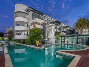 a building with a swimming pool in front of a building at Inner-City Brisbane 1-Bed with Pool Gym & Parking in Brisbane