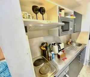 a small kitchen with a sink and a microwave at Cambridge City Centre Studio, Sleeps 3 in Cambridge