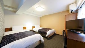 APA Hotel Osaka-Tanimachi tesisinde bir odada yatak veya yataklar