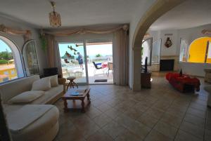 ein Wohnzimmer mit einem Sofa und einem Tisch in der Unterkunft Villa Cumbre del Sol in Cumbre del Sol