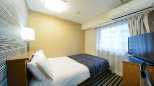 APA Hotel Osaka-Tanimachi tesisinde bir odada yatak veya yataklar