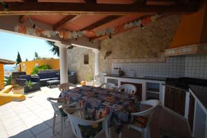 eine Küche mit einem Tisch und Stühlen auf einer Terrasse in der Unterkunft Villa Cumbre del Sol in Cumbre del Sol