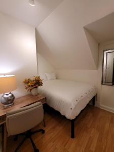 sypialnia z łóżkiem i biurkiem z lampką w obiekcie The Auditorium Suite w mieście Kitchener