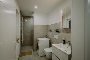 La salle de bains est pourvue de toilettes blanches et d'un lavabo. dans l'établissement Passaus Motto Appartements! Solo - Pärchen - Familien - Gruppen, à Passau