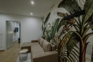 a living room with a couch and a wall mural at Passaus Motto Appartements! Solo - Pärchen - Familien - Gruppen in Passau