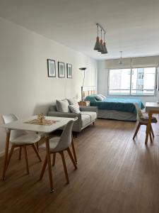 uma sala de estar com um sofá e uma mesa em Hermoso apartamento a 150 metros de la rambla em Montevidéu