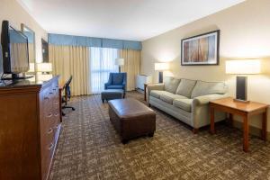 - un salon avec un canapé et une télévision dans une chambre d'hôtel dans l'établissement Pear Tree Inn St. Louis Near Union Station, à Saint-Louis