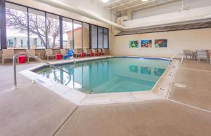 a swimming pool in a large room with a person in it at Pear Tree Inn St. Louis Near Union Station in Saint Louis