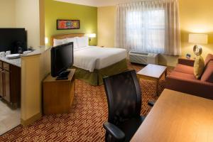 um quarto de hotel com uma cama e uma televisão de ecrã plano em Sonesta Simply Suites Phoenix Scottsdale em Scottsdale
