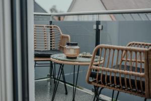 d'une petite table et de chaises sur un balcon. dans l'établissement Passaus Motto Appartements! Solo - Pärchen - Familien - Gruppen, à Passau