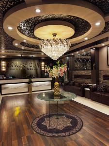 vestíbulo con mesa de cristal y lámpara de araña en Oxygym Hotel Faisalabad, en Faisalabad