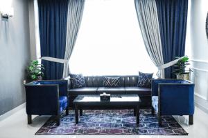 費薩拉巴德的住宿－Oxygym Hotel Faisalabad，客厅配有黑色沙发和蓝色椅子