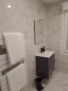 a white bathroom with a sink and a mirror at 24h course/Moto/ Oasis / Antares in Le Mans