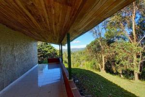 a porch with a bench under a wooden roof at Finca Cottage Guarne, nearby Arvi and Santa Elena in Guarne