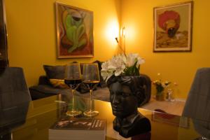 un tavolo con bicchieri da vino e un busto di testa di ArtE Vitosha Blvd a Sofia