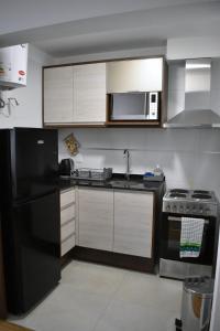 a kitchen with a black refrigerator and a microwave at Hermoso apartamento a 150 metros de la rambla in Montevideo