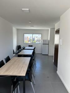 una sala de conferencias con mesas, sillas y nevera en Hermoso apartamento a 150 metros de la rambla en Montevideo