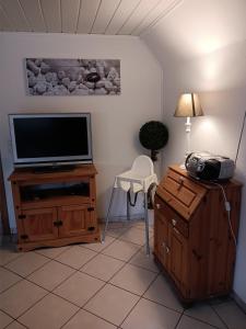uma sala de estar com televisão num suporte de madeira em Ostsee-Ferienwohnung-Nautikuss em Wangels
