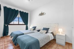 1 dormitorio con 2 camas y ventana en Casa Isabel, en Playa Honda