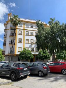 塞維利亞的住宿－Bonito y tranquilo apartamento en Nervión，停在大楼前的一组汽车