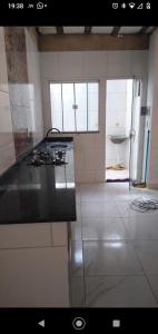 uma cozinha com um fogão e um lavatório em DC residencial em Tibau