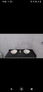 uma casa de banho com dois lavatórios num quarto em DC residencial em Tibau