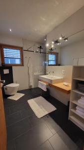 a bathroom with a tub and a toilet and a sink at Chasa Scandella - Apartment Carl in Sent