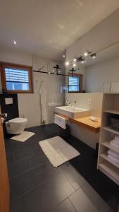 ein Badezimmer mit einer Badewanne, einem WC und einem Waschbecken in der Unterkunft Chasa Scandella - Apartment Carl in Sent