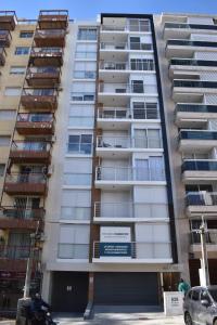a tall apartment building with a sign on it at Hermoso apartamento a 150 metros de la rambla in Montevideo