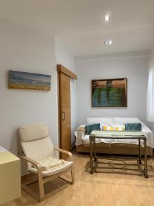 1 dormitorio con 1 cama, 1 silla y 1 mesa en Bonito y tranquilo apartamento en Nervión, en Sevilla