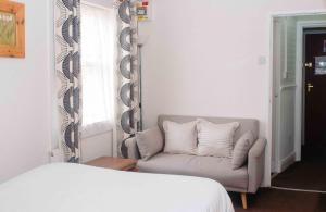 1 dormitorio con sofá, espejo y cama en THE CHADWICK, en Skegness
