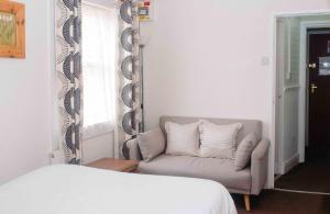 a bedroom with a couch and a mirror and a bed at THE CHADWICK in Skegness
