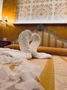 uma pilha de toalhas brancas numa cama em Casa belvedere luxury em Anzio