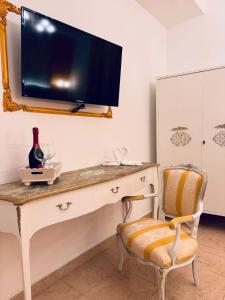 um quarto com uma secretária, uma televisão e uma cadeira em Casa belvedere luxury em Anzio