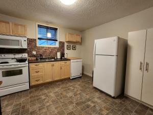 a kitchen with white appliances and wooden cabinets at Peaceful suite near the lake in Victoria