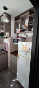 cocina con nevera blanca y fregadero en Departamento 2 ambientes en Buenos Aires