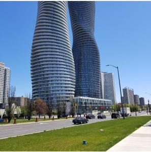 dos edificios altos en una ciudad con coches en una calle en Lovely 1 bedroom Condo Downtown Mississauga Square One, en Mississauga