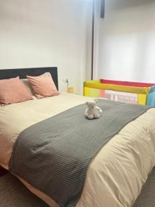 a teddy bear sitting on top of a bed at Mi pisito en el Temple in A Coruña