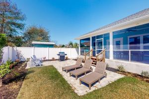 eine Terrasse mit zwei Stühlen und einem Grill vor einem Haus in der Unterkunft Turtle Beach Retreat in Panama City Beach