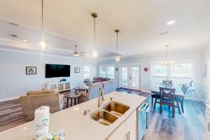 eine Küche mit Spüle und ein Wohnzimmer in der Unterkunft Turtle Beach Retreat in Panama City Beach