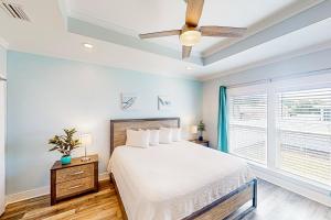 ein Schlafzimmer mit einem Bett und einem Deckenventilator in der Unterkunft Turtle Beach Retreat in Panama City Beach
