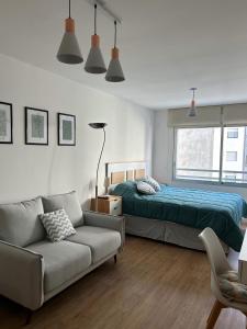 sala de estar con cama y sofá en Hermoso apartamento a 150 metros de la rambla en Montevideo
